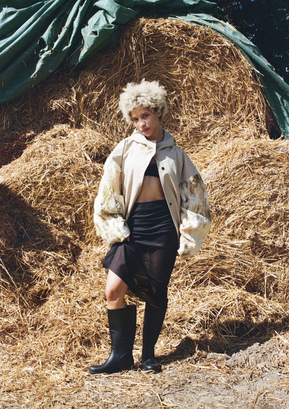Felted cream jacket with a sheer black skirt in front of hay